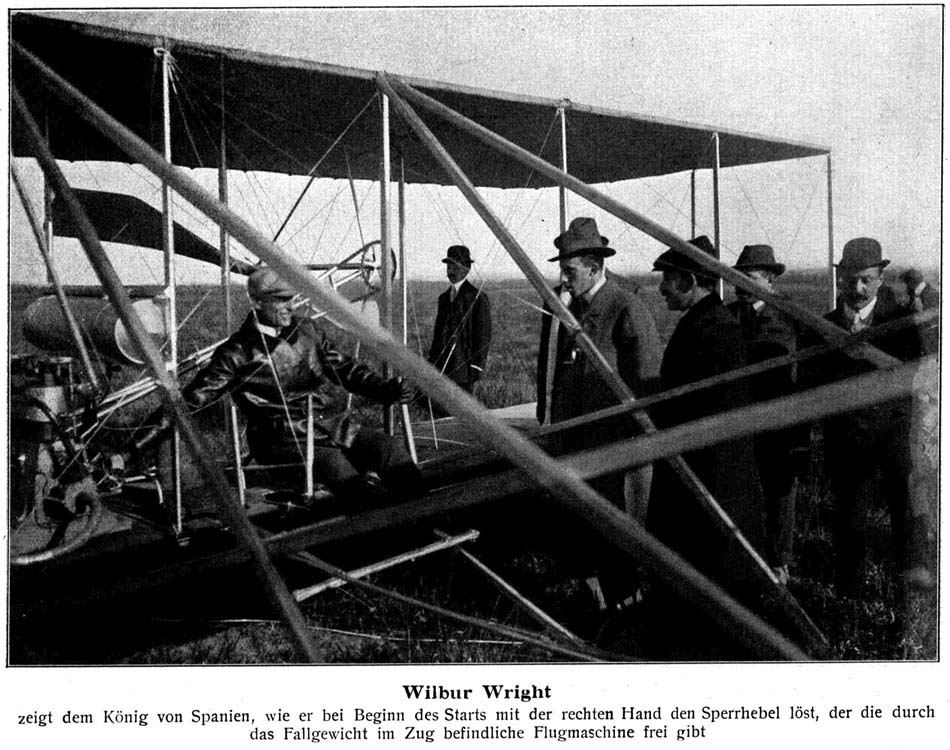 Wilbur Wright: Zeigt dem K&ouml;nig von Spanien, wie er bei Beginn des Starts mit der rechten Hand den Sperrhebel l&ouml;st, der die durch das Fallgewicht im Zug befindliche Flugmaschine frei gibt.