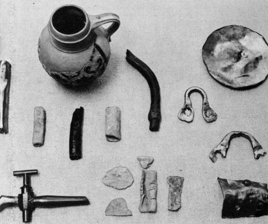 [Illustration: Lead and copper pipes, kettle fragments, a brass spigot, and other items found which may have been used for brewing or distilling purposes.]