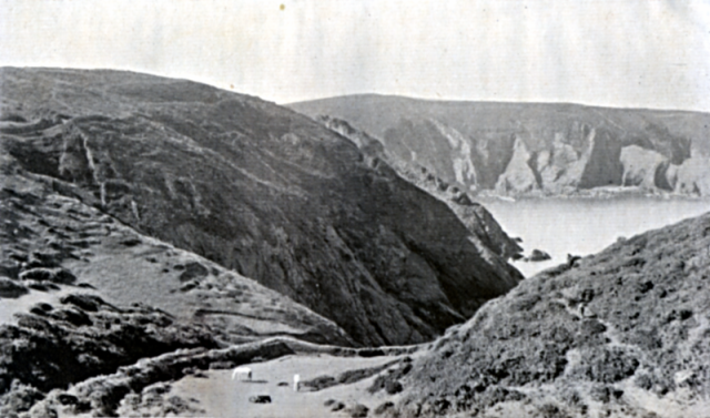 BELOW BEAUMANOIR. "And in Sercq, the headlands were great soft cushions of velvet turf, the heather purpled all the hillsides, and, on the gray rocks below, the long waves shouted aloud because they were free." This is the slope below "BEAUMANOIR," looking into PORT ES SAIES.