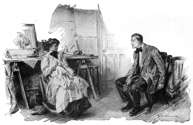 A seated man and woman chat.