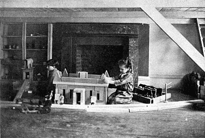 Girl playing with dolls house.