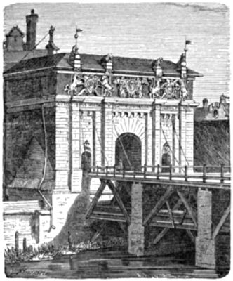 A heavy stone gatehouse at the end of a bridge