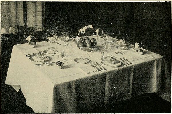 A Dinner Table, with Fruit Centerpiece, and Nuts in Individual Baskets