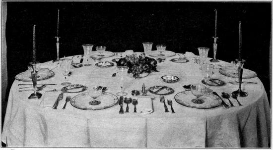 Photo by Bradley and Merrill. Courtesy of the Pictorial
Review.

TABLE SET FOR DINNER

The decoration in the center of the table should never be so high as to
form an obstruction