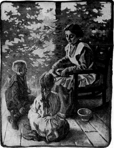 Seated woman with two children kneeling on the floor before her