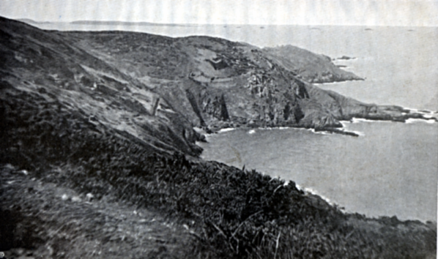 THE EPERQUERIE. Above the shoulder of the hill to the left, JETHOU just appears; the larger island with the long painted beak is HERM, with her string of islets like a fleet of ships speeding to the north. The lower of the two out-jutting headlands is where the Herm men landed. The higher is BEC DU NEZ, the most northerly point of SARK.