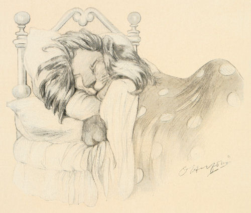 A lion snuggled up asleep in bed, under a polkadot patterned comforter