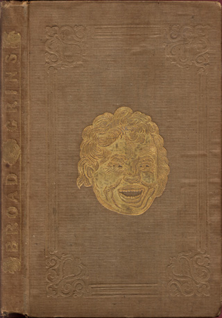 Brown cloth cover with gold-stamped smiling face in the center. The spine has the name of the book on it, also in gold.