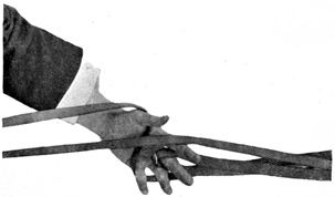 Fig. 76.—Double reins in left hand: one crossed, the
other hooked up on middle finger.