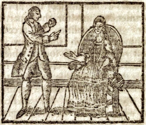 A man standing, facing a seated woman
