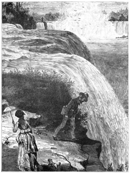 A man peers over the top edge of one of the waterfalls; a woman and dog are nearby