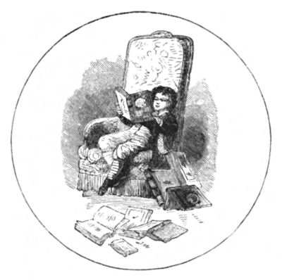 A boy sits reading in an armchair