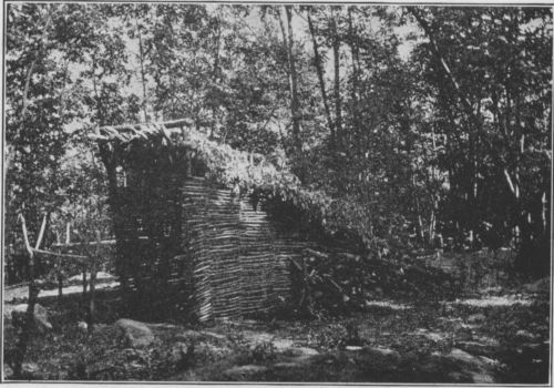 The complete lean-to, showing fire place, wood pile and table to right. Cache is in back.