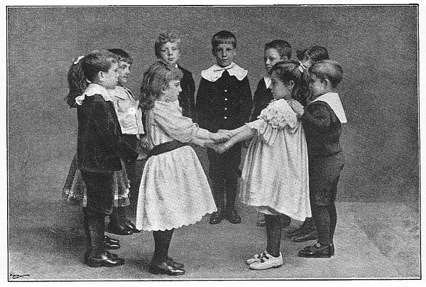 Two children holding hands while the rest of the children act as the walls of the house