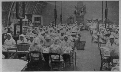BANDAGES BY THE TENS OF THOUSANDS
An atelier workshop of the A. R. C. in the Rue St. Didier, Paris, daily turned out surgical dressings by the mile