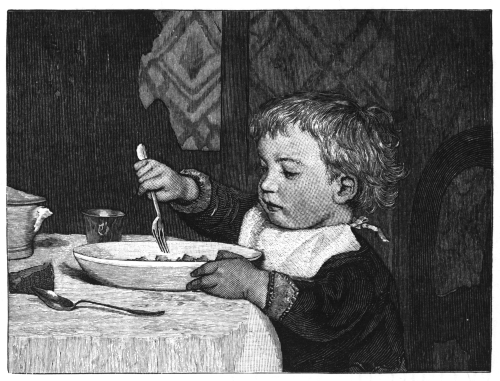 Toddler feeding himself at the table