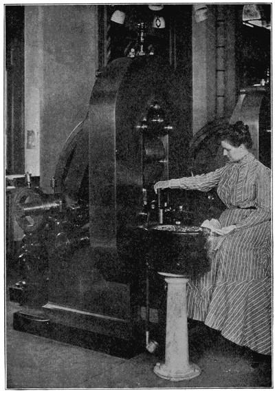 Lady operating electric coin press