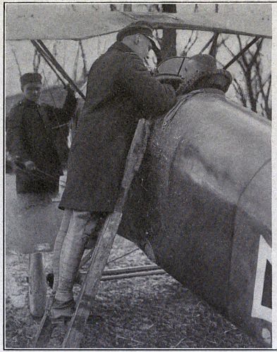 Man on ladder talking to pilot in cockpit