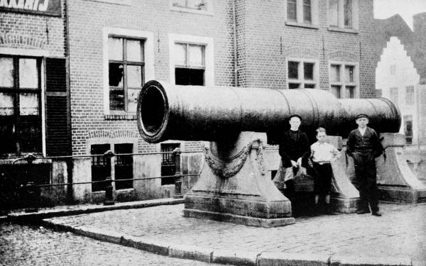 photo children standing by large cannon in a city