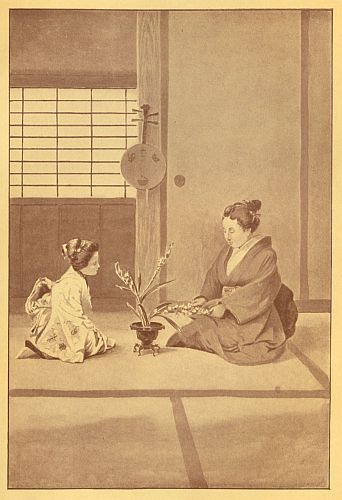 little girl and woman on floor with vase of flowers between them