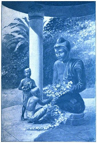 children giving flowers to statue of Buddha