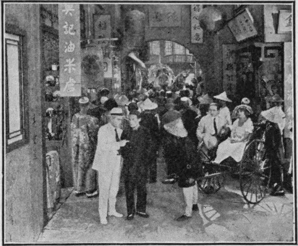 Houdini talking with a man in busy street scene