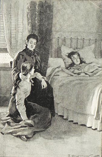 woman on chair by bed with a girl lying in it and another girl at woman's feet