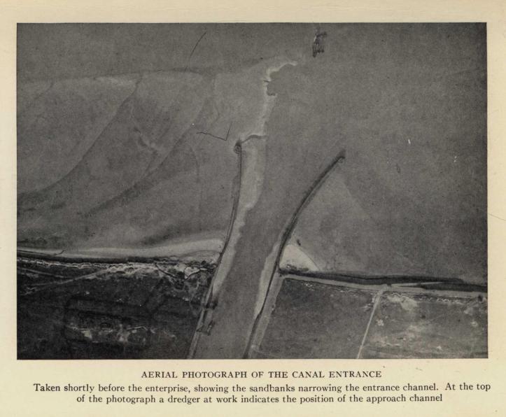 AERIAL PHOTOGRAPH OF THE CANAL ENTRANCE. Taken shortly before the enterprise, showing the sandbanks narrowing the entrance channel.  At the top of the photograph a dredger at work indicates the position of the approach channel