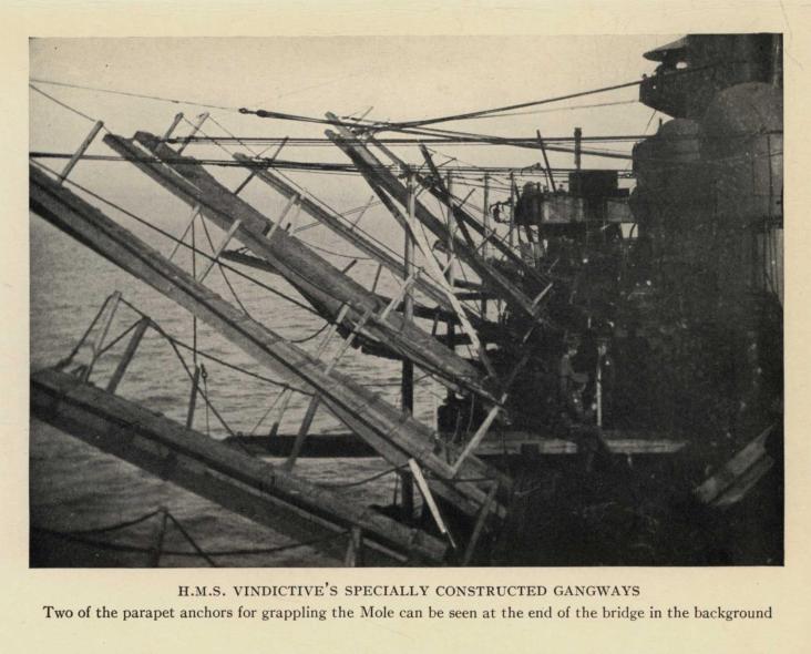 H.M.S. VINDICTIVE'S SPECIALLY CONSTRUCTED GANGWAYS. Two of the parapet anchors for grappling the Mole can be seen at the end of the bridge in the background
