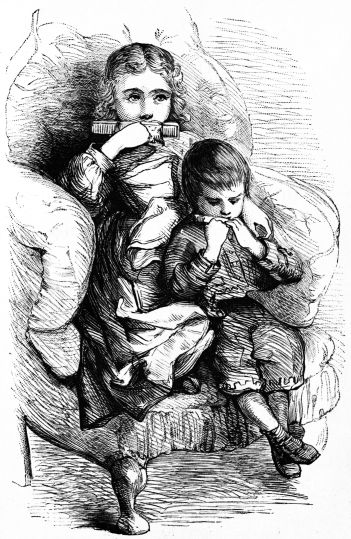 two children sitting in a chair playing combs
