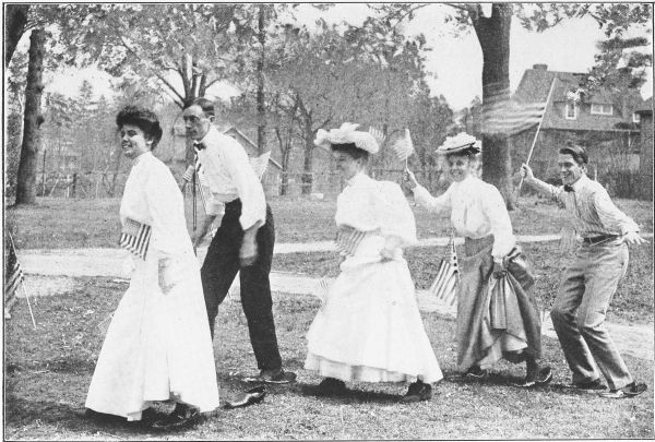 Photo of three young women and two young men having a very good time "racing"