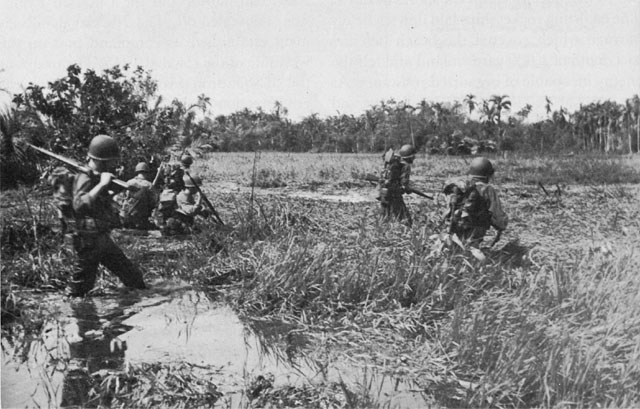 TROOPS OF THE 1ST CAVALRY DIVISION wade through a swamp to their A-Day objective.