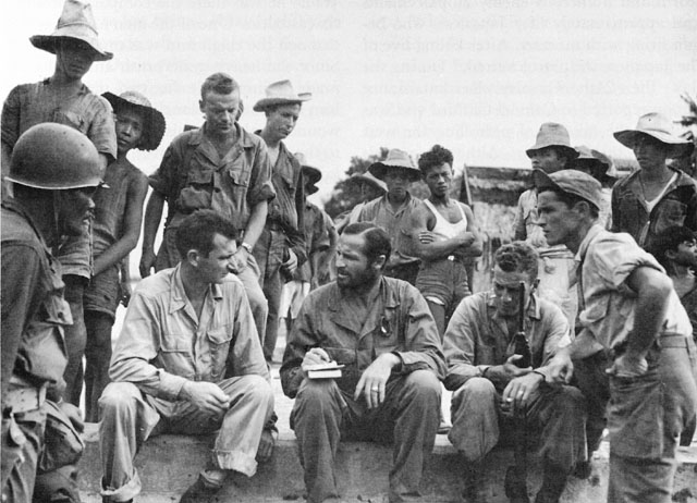 LT. COL. THOMAS E. CLIFFORD, JR., discusses plans with his staff as Filipino guerrillas look on.