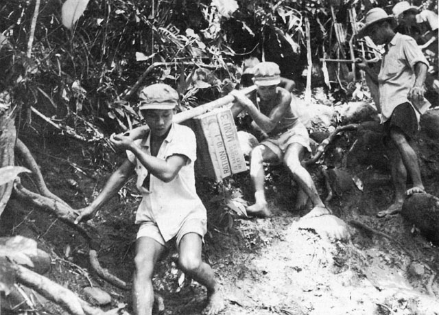 FILIPINO CARRIERS HAUL SUPPLIES over slippery mountain trails for the 12th Cavalry.