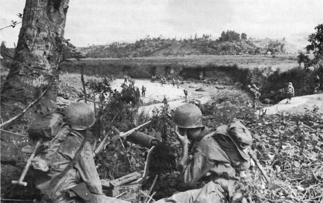 HEAVY MACHINE GUNS COVER CROSSING of the Antilao River by men of the 77th Division at Ormoc.