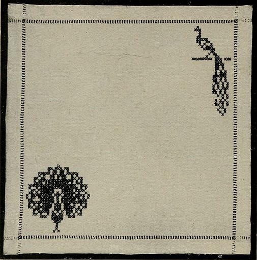 square of fabric with embriodered peacock on on roost in upper right corner and peacock with tail fanned out in lower left corner
