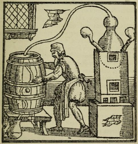 man working a still with a barrel on one side and what looks like a smoker on the other