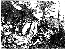 Men are praying near a rock outside of a city.