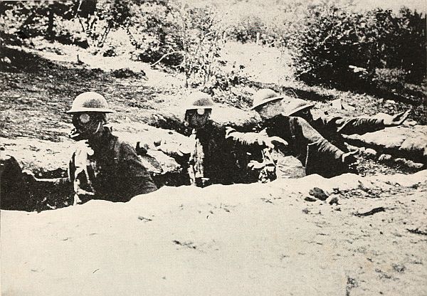 three men in trench wearing gas masks