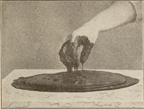 chocolate covered hand above melted chocolate on slab