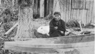 WATERMAN—CANOES  PL. IV  BOW OF THE HULL SHOWN IN PLATE V, VIEWED FROM THE SIDE, WITH THE MAKE1’S WIFE, MARY ADAMS (TAI´PΔS) SEATED BESIDE IT  (Photograph by J. D. Leechman.)