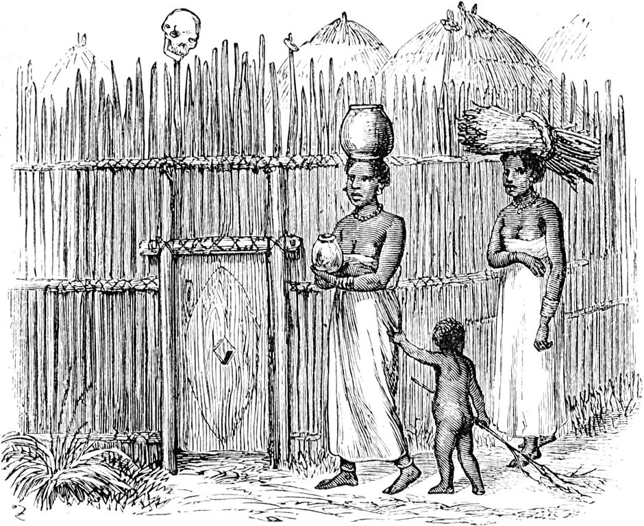 Zwei Frauen und ein Kind   nähern sich dem Eingang ihres umzäunten Dorfes