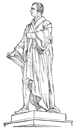 A statue of a man standing in flowing robes, holding a tablet.