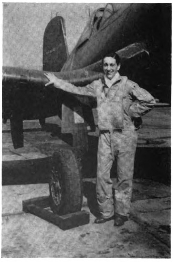 A young man standing with his hand on an airplane wing