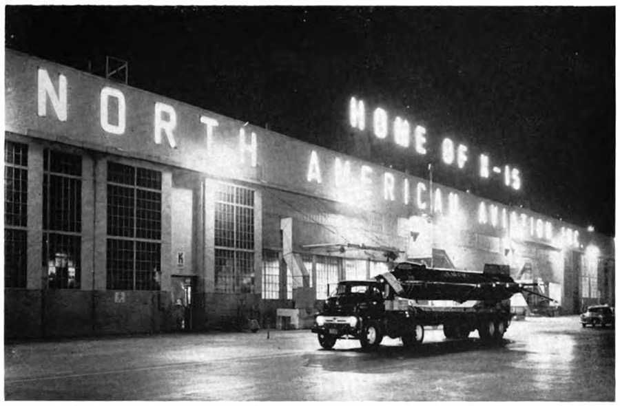 Truck driving at night with a sign saying 'Home of X⁠-15 North American' in the background