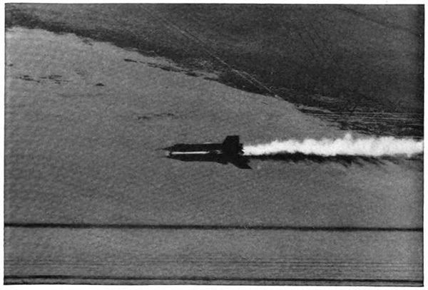 A plane in the air with a bright contrail