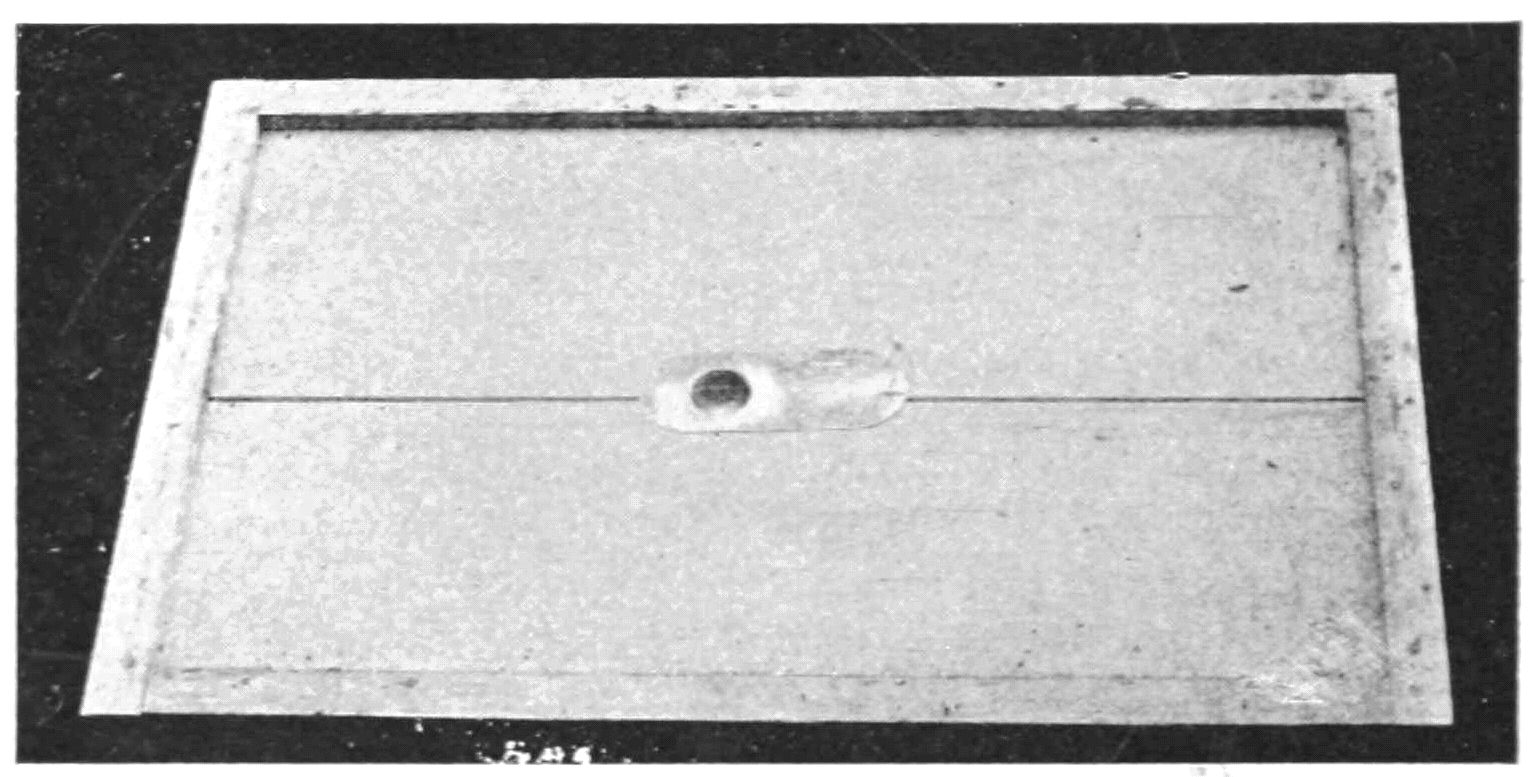 A framed roughly square made of two planks of wood, with a hole in the center.