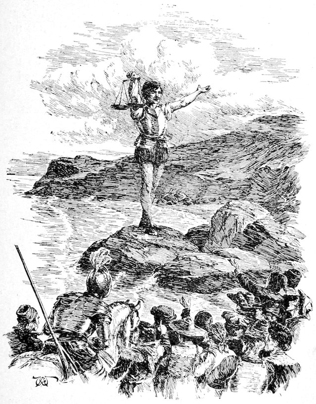 A person standing on a rock by the water holding up a set of scales, while a group of people look on from the foreground.