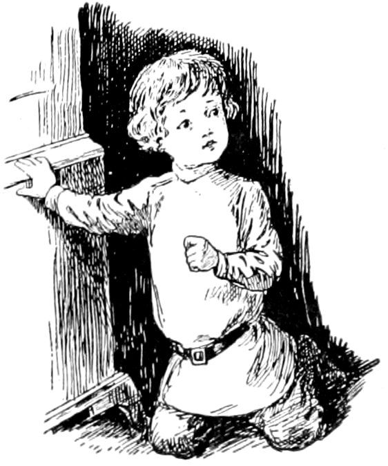 A young child kneeling on the floor, holding onto the edge of a piece of furniture while looking up and ahead.