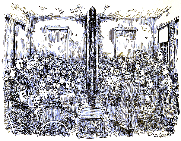 People gathered in the room of a building, majority being seated. A man is standing at the front and reading from a book.